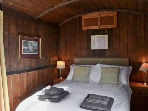 a bedroom with a bed with two towels on it at The Guards Van in Wetheringsett