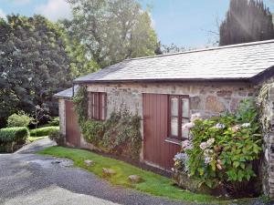 a small stone cottage with a red door at The Blacksmiths Shop in Lanlivery