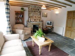 a living room with a couch and a table at Porth Nanven Barn in St Just