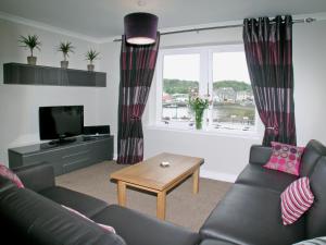 a living room with a couch and a window at Kerrera View in Oban