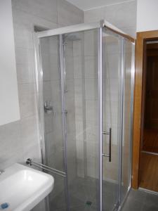 a shower with a glass door next to a sink at Ferienwohnung Enn in Neukirchen am Großvenediger