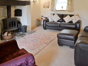 sala de estar con sofá y chimenea en Bee Bowl Cottage - Httd, en Bideford