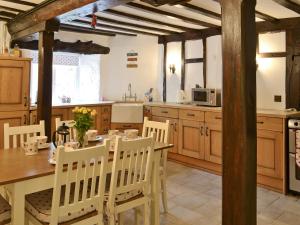 cocina con mesa de madera y sillas en una habitación en Bee Bowl Cottage - Httd, en Bideford