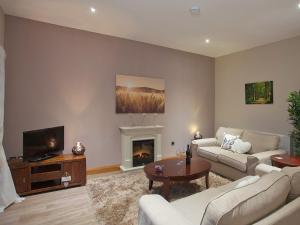 a living room with a couch and a fireplace at One The Old Stables in Knitsley