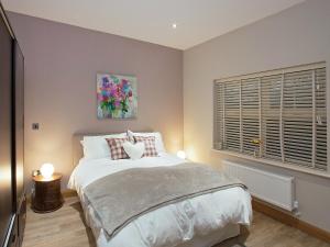 a bedroom with a bed with two lamps and a window at One The Old Stables in Knitsley