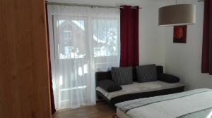 ein Wohnzimmer mit einem Sofa und einem Fenster in der Unterkunft Ferienwohnung Enn in Neukirchen am Großvenediger