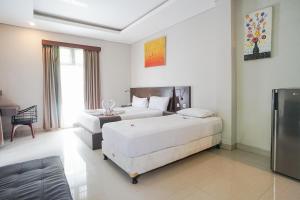 a hotel room with two beds and a couch at Akarsa Transit in Sanur