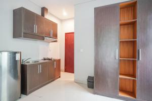 a kitchen with wooden cabinets and a stainless steel refrigerator at Akarsa Transit in Sanur