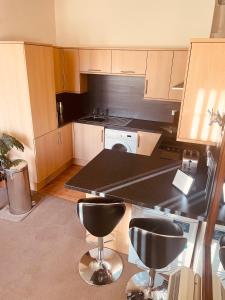 a kitchen with a black counter and some bar stools at Glenfiddich in Nairn