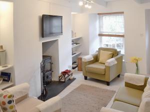 a living room with a fireplace and a tv at Bucca Cottage in Newlyn