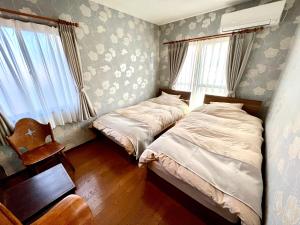 a bedroom with two beds and a chair at lifeone club in Hiroshima