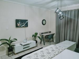 a bedroom with two beds and a table and a desk at Hatfield Grosvenor Private Apartments in Pretoria