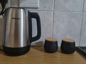 a coffee pot and two cups on a counter at Hatfield Grosvenor Private Apartments in Pretoria