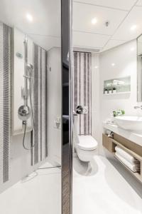 a bathroom with a shower and a toilet and a sink at Metaplace Hotel in Hong Kong