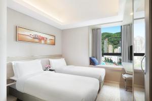 - 2 lits dans une chambre d'hôtel avec fenêtre dans l'établissement Metaplace Hotel, à Hong Kong