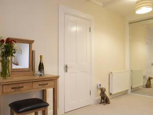 um quarto com uma porta branca, um banco e um espelho em Kinneddar Cottage em Saline