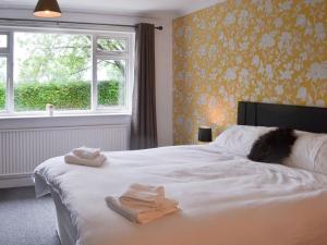 a bedroom with a white bed with towels on it at Glebe Farm Bungalow in Market Rasen