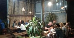 a group of people sitting at tables in a restaurant at Happy bungalow & trekking in Banlung