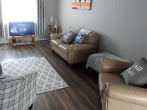 a living room with a couch and a tv at Seashore Hideaway in Newbiggin-by-the-Sea