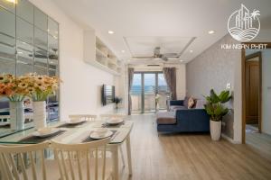 a living room with a table and a blue couch at Kim Ngan Phat Deluxe Apartment in Danang
