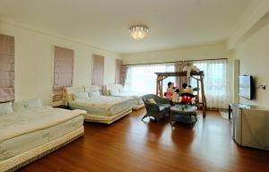 Qixingtan Hai Wan B&B في Dahan: غرفة معيشة كبيرة مع سريرين وطاولة