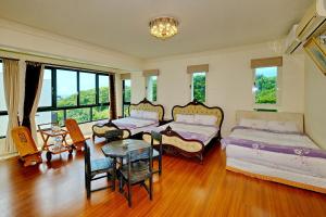 1 dormitorio con 2 camas, mesa y sillas en Qixingtan Hai Wan B&B en Dahan