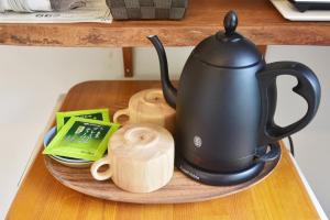 a black tea kettle on a plate on a table at Gardenvilla Shirahama in Shimoda