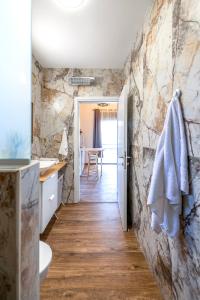 een badkamer met een stenen muur, een wastafel en een toilet bij מול בנטל in Ein Zivan