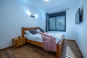 1 dormitorio con cama y ventana en מול בנטל en Ein Zivan