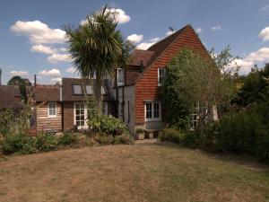 una casa con una palmera delante de ella en Apple Tree Cottage, en Horsham