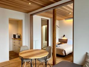 a bedroom with a bed and a table and chairs at Gardenvilla Shirahama in Shimoda