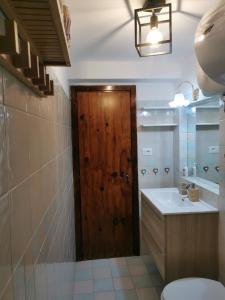 a bathroom with a toilet and a wooden door at Casa Vacanza Pescocostanzo in Pescocostanzo