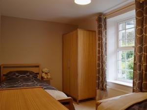 1 dormitorio con 1 cama, armario y ventana en Ellers Bank en Hayfield