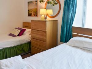 1 dormitorio con 2 camas individuales y espejo en Meadowbank Lodge, en Staveley