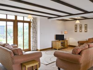 a living room with couches and a flat screen tv at Mint - E4322 in Ludham