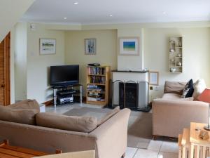 a living room with a couch and a television at Sea Shells in Padstow