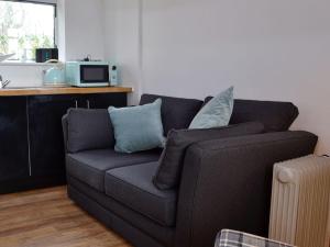a living room with a couch and a microwave at Grooms Room in Aberdare