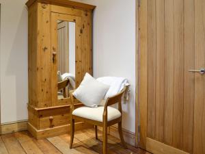 Cette chambre comprend une chaise et un miroir. dans l'établissement Grooms Room, à Aberdare