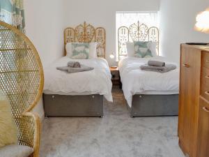 ブリクサムにあるSamphire Lodgeのベッド2台とドレッサーが備わる客室です。