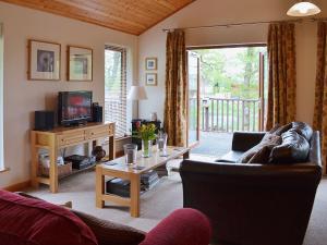 a living room with a couch and a tv at Rowanburn Lodge in Ellonby