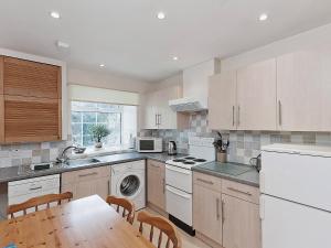 a kitchen with white appliances and a wooden table at Peartree Farm Cottages - Rchm39 in Ebberston