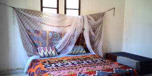 a bedroom with a bed with a mosquito net at Auberge Triskell in Nouakchott