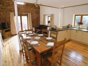 a dining room and kitchen with a table and chairs at The Street Farm Barn in Drayton