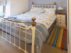 Dunvant的住宿－戴爾瑞鄉村別墅，一间卧室配有一张床和一个带床罩的床头柜。