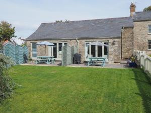 a house with a yard with two picnic tables at The Dairy in Dunvant
