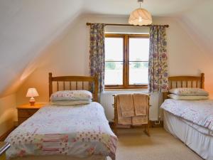 - 2 lits dans une chambre avec fenêtre dans l'établissement Copper Cottage, à Burgh Saint Peter
