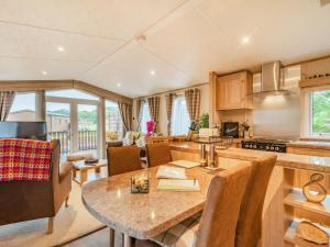 a kitchen and living room with a table and chairs at Woodlands in Sewerby