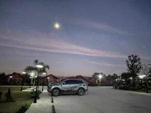 Un todoterreno estacionado en un estacionamiento por la noche en HR Resort 