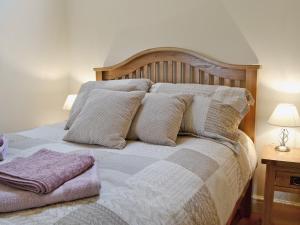 a bed with a wooden head board and pillows at Nice Home In Wales W- in Strata Florida