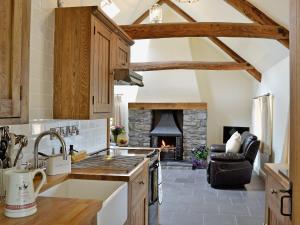 a kitchen with a stove top oven next to a fireplace at Nice Home In Wales W- in Strata Florida